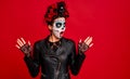 Dead gir with sugar skull makeup with a wreath of flowers on her head and skull, wearth black gloves opene her mouth in shock