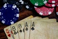Dead Mans Hand Top Macro with vintage used cards and poker chips in blue, red, green and Black on a wood table with soft warm Royalty Free Stock Photo