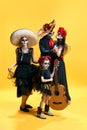 Dead mexican family with sombrero on halloween night. Studio shot of zombies isolated on yellow background. day of the Royalty Free Stock Photo