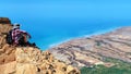 Dead Sea coast view point. Traveler sit on the rock edge and looks out. Israel