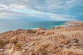 Dead sea shore at Jordan side, dry sand and rocks beach, sun shines on beautiful azure water surface Royalty Free Stock Photo