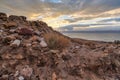 Dead sea shore at Jordan side, dry sand and rocks beach, sunset sky above calm water background Royalty Free Stock Photo