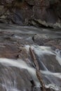 Deadfall log across boulders in a fast moving mountain stream