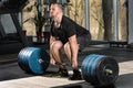 Deadlift attempt. Young man trying to lift heavy barbell