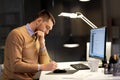 Man with notepad working on code at night office Royalty Free Stock Photo