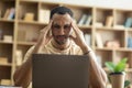 Deadline stress. Exhausted arab man tired after working on laptop, having headache and touching head, sitting at desk