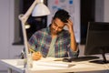 Creative man with notebook working at night office Royalty Free Stock Photo