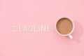 DEADLINE text with a cup of coffee with shadow on pink background. Royalty Free Stock Photo