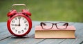 Deadline, time concept, alarm clock with book and eyeglasses