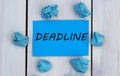 DEADLINE - word on blue paper on a light background with crumpled pieces of paper