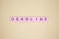 Deadline word wooden cubes on yellow background.