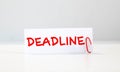 Deadline word written on a post note and hanged on the cork-board with an old pocket watch Royalty Free Stock Photo