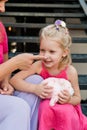 Deaf child with cochlear implant for hearing audio and aid for impairment having fun and laughs with mother outdoor in