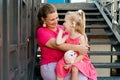 Deaf child with cochlear implant for hearing audio and aid for impairment having fun and laughs with mother outdoor in