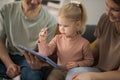 Deaf child girl with cochlear implant studying to hear sounds and have fun with mother and father - recovery after