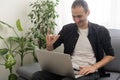 Deaf or hard hearing happy smiling young caucasian man uses sign language while video call using laptop while sitting on