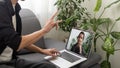 Deaf or hard hearing happy smiling young caucasian man uses sign language while video call using laptop while sitting on