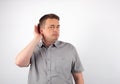 Deaf senior man cupping hand behind ear trying to hear Royalty Free Stock Photo