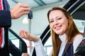 Dealer, female client and auto in car dealership