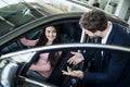 Dealer man showing a new car model to the potential customer Royalty Free Stock Photo