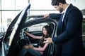 Dealer man showing a new car model to the potential customer Royalty Free Stock Photo