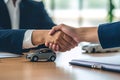 Dealer and new car owner handshake after concluding a deal. Concept of car dealerships, used cars, car sale and rent Royalty Free Stock Photo