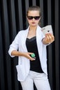 Dealer with poker chips and playing cards on abstract background. Woman in sunglasses holding casino chips posing for camera Royalty Free Stock Photo