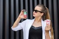 Dealer with poker chips and playing cards on abstract background. Woman in sunglasses holding casino chips posing for camera Royalty Free Stock Photo