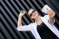 Dealer with poker chips and playing cards on abstract background. Woman in sunglasses holding casino chips posing for camera Royalty Free Stock Photo