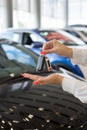 Dealer woman holding keys to a new car. Modern and prestigious vehicles Royalty Free Stock Photo