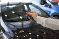 Dealer woman holding keys to a new car. Modern and prestigious vehicles Royalty Free Stock Photo