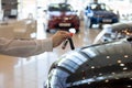 Dealer woman holding keys to a new car. Modern and prestigious vehicles. Royalty Free Stock Photo