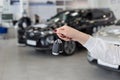 Dealer woman holding keys to a new car. Modern and prestigious vehicles Royalty Free Stock Photo