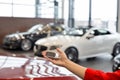 Dealer woman holding keys to a new car. Modern and prestigious vehicles Royalty Free Stock Photo