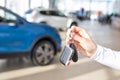 Dealer woman holding keys to a new car. Modern and prestigious vehicles Royalty Free Stock Photo