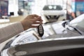 Dealer woman holding keys to a new car. Modern and prestigious vehicles. Royalty Free Stock Photo