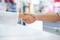 Dealings at the drugstore. a pharmacist shaking hands with a customer. Royalty Free Stock Photo