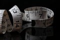 Coiled Dean Measurement Tailor Seamstress Tape Measure on a Black Reflective Surface Royalty Free Stock Photo