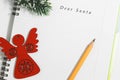 Dear Santa, Notebook and yellow pencil with wooden red angel Royalty Free Stock Photo