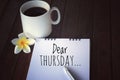 Dear Thursday note message on white spiral notebook. Thursday plans and hope concept.  With a cup of morning coffee and notepad. Royalty Free Stock Photo