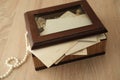 Dear to heart memorabilia in an old wooden box, pearl beads, stack of retro photos, vintage photographs of 40s - 50s, concept