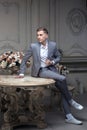 Dear young man with a haircut in a suit, sitting at a table in a room with a classic interior. Luxury. Male beauty Royalty Free Stock Photo