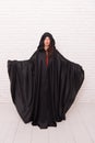 Death in black cloak symbol. Vampire in cloak sexy devil girl. Woman tempting vampire demon. Girl covered with cloak Royalty Free Stock Photo