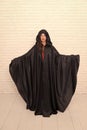 Death in black cloak symbol. Vampire in cloak sexy devil girl. Woman tempting vampire demon. Girl covered with cloak