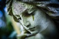 Death concept. Close Up of ancient stone statue of crying sad angel with tears in face as symbol of end of human life Royalty Free Stock Photo