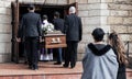 Death, funeral and people with coffin to church, chapel service and ceremony for temple ritual. RIP, mourning and burial Royalty Free Stock Photo