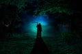 Death with a scythe in the dark misty forest. Woman horror ghost holding reaper in forest Royalty Free Stock Photo