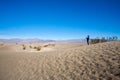 Man taking a picture alone among the sand dunes in Death Valley