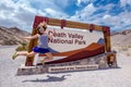 Sign for Death Valley National Park on an overcast summer day.. Woman jumps and poses Royalty Free Stock Photo