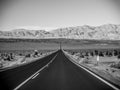 Death Valley, Mojave Desert lone empty road, California, USA: The hottest place on the planet Earth, black and white art photo Royalty Free Stock Photo